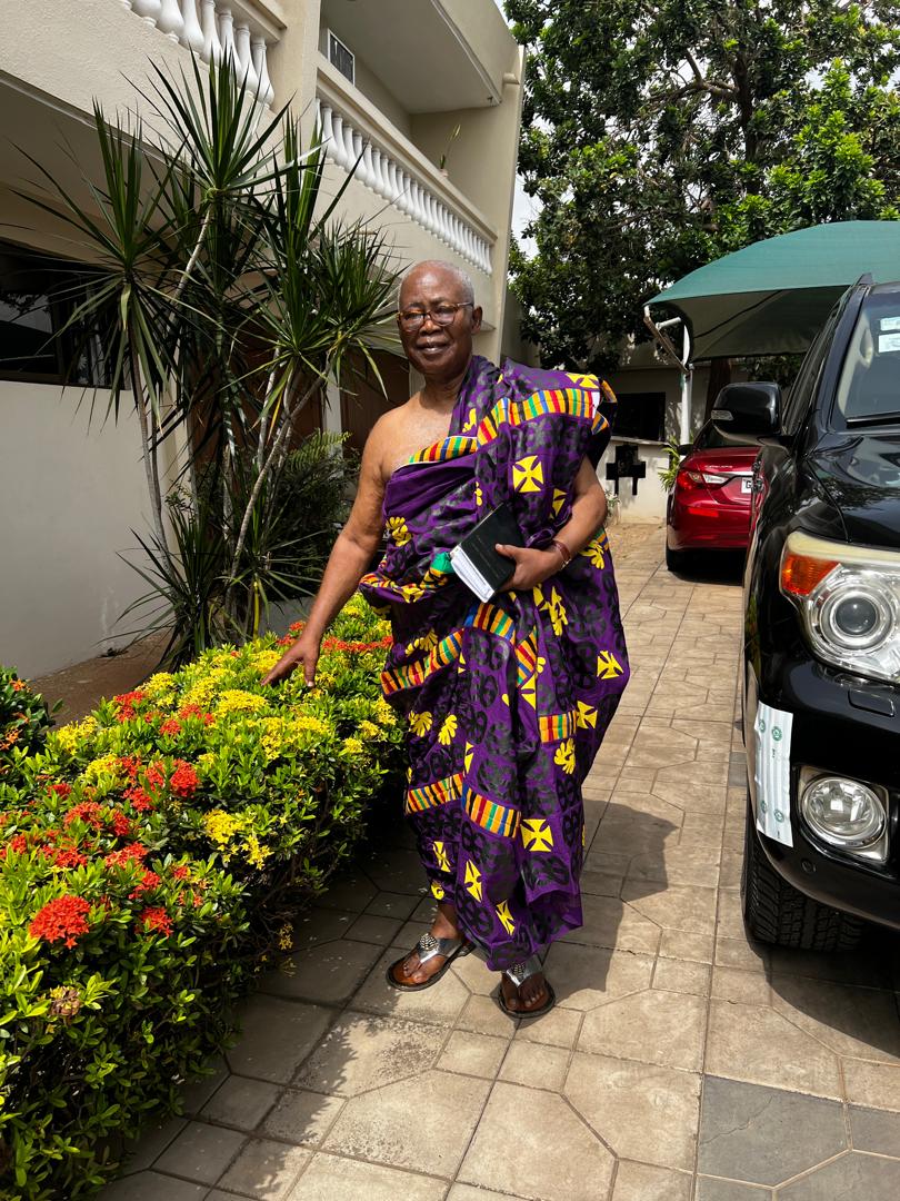 Walking outdoors in purple Kente